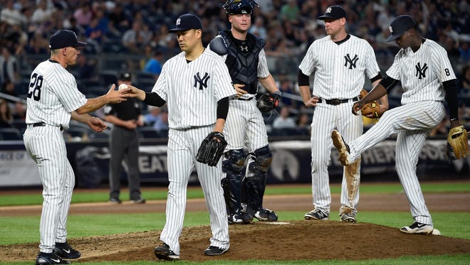 Yankees manager Joe Girardi  takes the ball from starting pitcher Masahiro Tanaka as catcher Brian McCann, third baseman Chase Headley, second from right, and shortstop Didi Gregorius wait on the mound in the seventh inning on Saturday, June 11. The Tigers won 6-1.