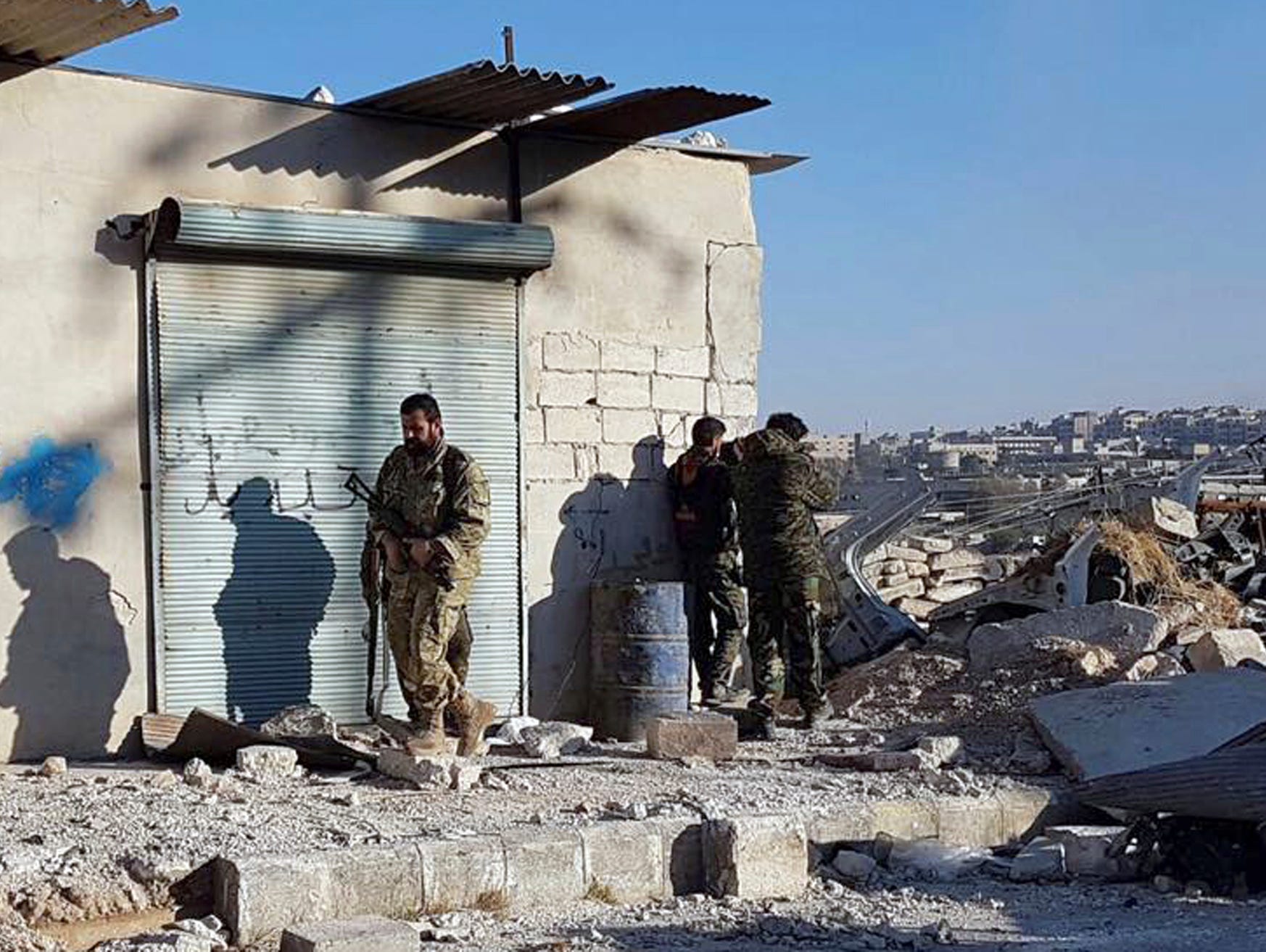 This Sunday, Nov. 27, 2016 photo provided by the Rumaf, a Syrian Kurdish activist group, which has been authenticated based on its contents and other AP reporting, shows Kurdish fighters watch people flee from rebel-held eastern neighborhoods of Alep