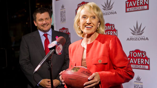 Arizona Cardinals president Michael Bidwill and Gov. Jan Brewer celebrate winning hosting rights to Super Bowl XLIX in 2015 during a press conference outside Tom's Tavern in Phoenix on Oct. 11, 2011.