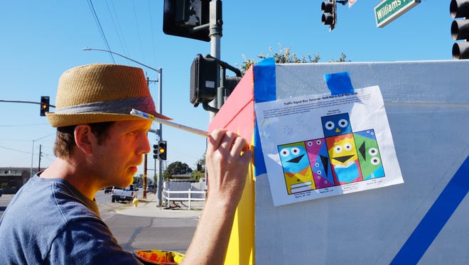 Artist Drew McSherry works on painting a utility box at the corner of Willams Rd. and Bardin, next to the Cesar Chavez Library in east Salinas. 