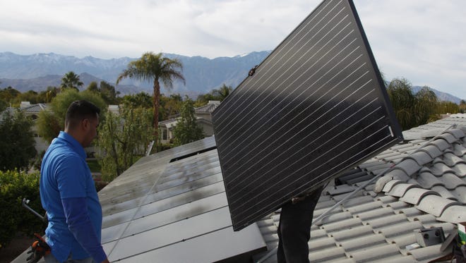 Planet Solar construction manager Ezequiel Alvarez (left) and Juan Arroyo finish installing rooftop panels at a home in Rancho Mirage on Jan. 22, 2016.