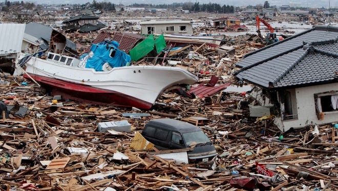 A fishing boat sits amongst debris of houses and cars in Natori, Miyagi Prefecture, Japan on March 21, 2011, following the March 11 earthquake and tsunami that devastated the northeast coast of Japan.