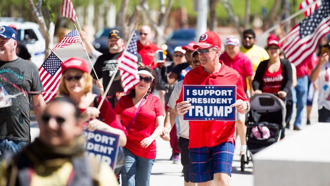 Demonstrators participate in a march in support of President Trump in Phoenix on Saturday, March 25, 2017.