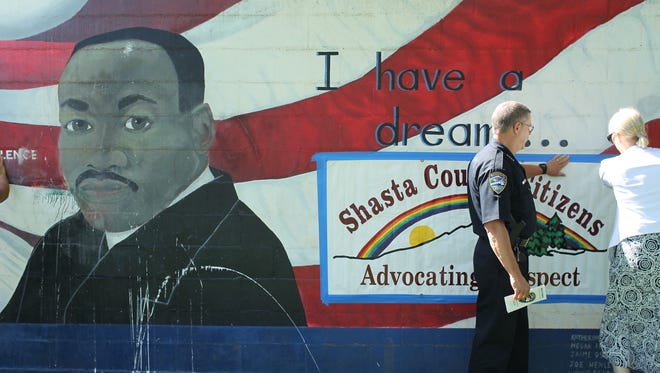 Redding Police Chief Pete Hansen helps an organizer put up a poster at the MLK Center in Redding