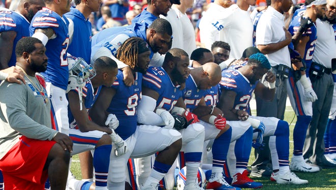 In this Sunday, Sept. 24, 2017, file photo, Buffalo Bills players take a knee during the playing of the national anthem before an NFL football game against the Denver Broncos in Orchard Park, N.Y.