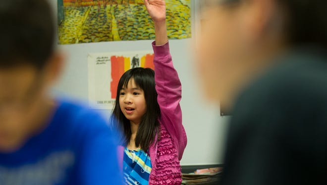 Milla Nguyen raises her hand in her fifth grade art class at Basis School in Chandler in 2013.