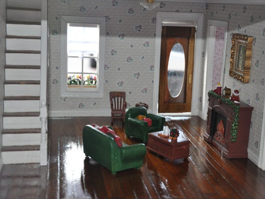 The restored dollhouse features Christmas-themed décor.