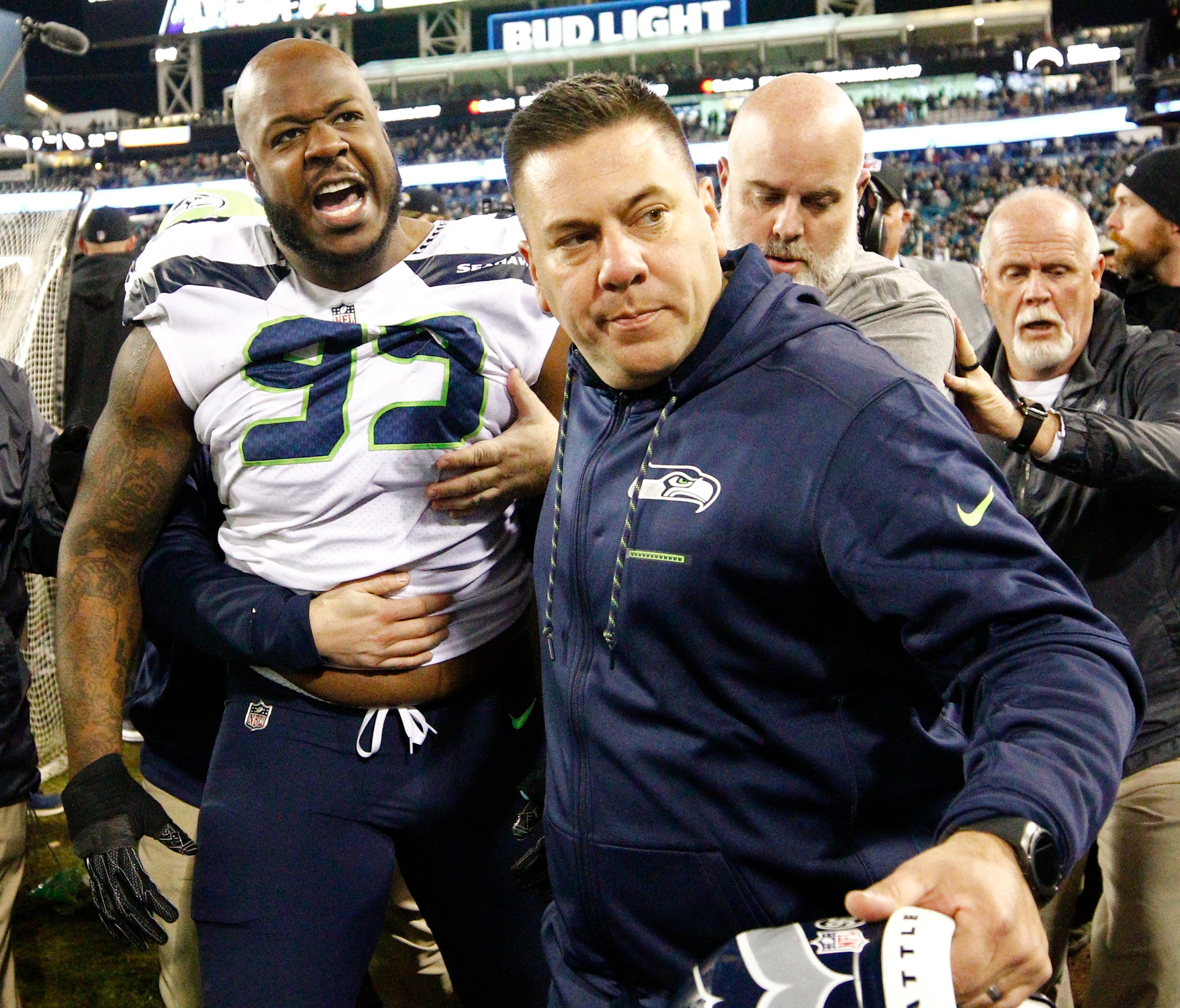 Members of the Seattle Seahawks staff escort Seattle Seahawks defensive tackle Quinton Jefferson (99) off the field after he got into a shouting match with fans when objects were thrown at him after an NFL football game against the Jacksonville Jagua