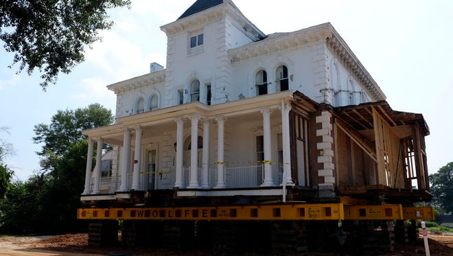 The Wilkins House on Augusta Street sits up on dollies in preparation to be moved.