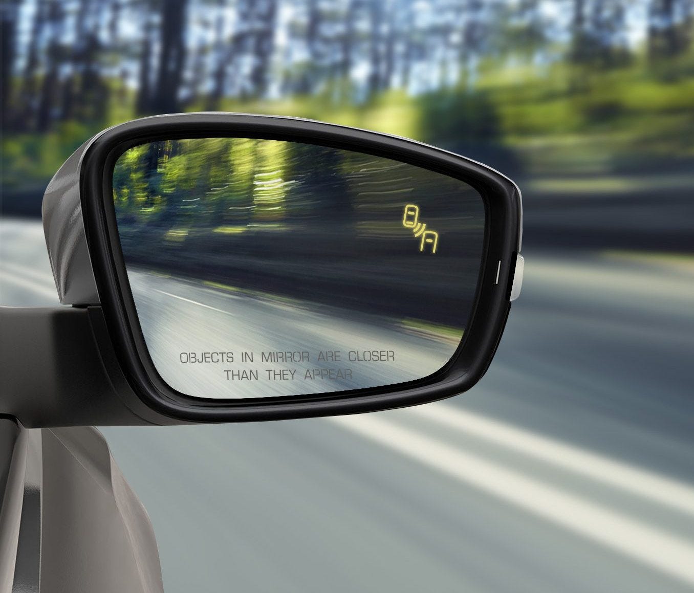 A blind spot monitoring system in this Volkswagen vehicle activates a small, lighted icon in the side-view mirror.