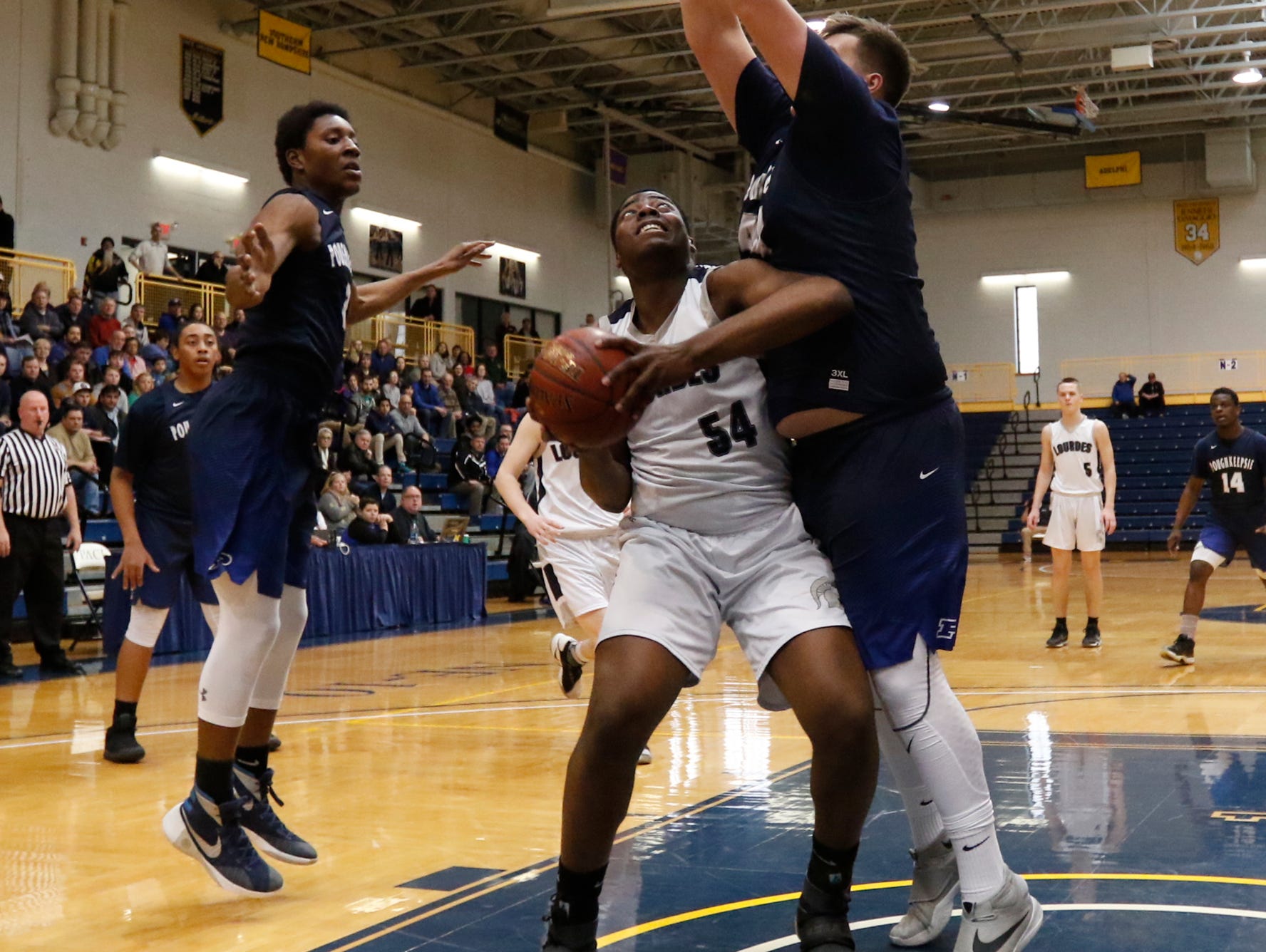 Our Lady of Lourdes High School's James Anozie looks for space as Poughkeepsie's Cory Simmons defends during the Class A regional finals at Pace University in Pleasantville on March 11.