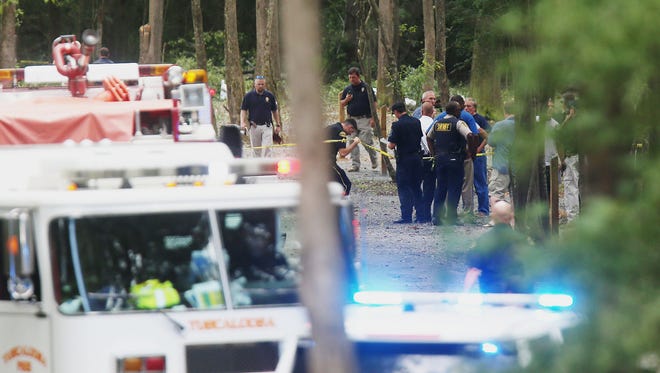 Authorities work the scene of a plane crash at a park along Robert Cardinal Airport Road across from the Tuscaloosa Regional Airport in Northport, Ala., Sunday, Aug. 14, 2016. Authorities said several people are dead following the crash of a small airplane near Tuscaloosa, Alabama. (Erin Nelson/The Tuscaloosa News via AP)