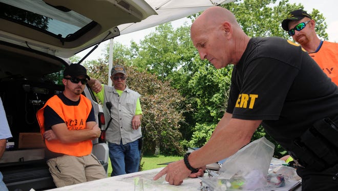Joe Minney points out the area they are searching on a map Monday, June 22, 2015, at a command station set up off of U.S. 50. The body of Tiffany Sayre was found Saturday night off of Cave Road.