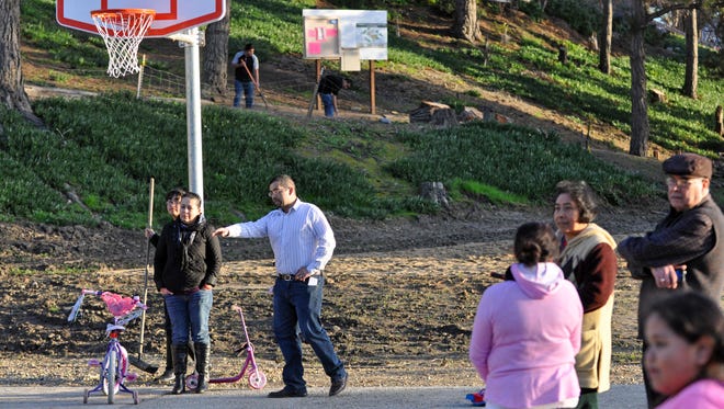 During a community cleanup on Wednesday, Joel Hernandez from the Center for Community Advocacy works with residents to note remaining  issues before the Acosta Plaza Recreation Area can be officially opened. 