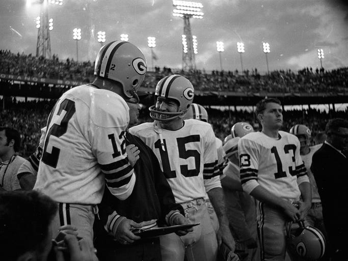 Green Bay Packers quarterbacks Zeke Bratkowski (12) and Bart Starr (15) celebrate near the end of Super Bowl II against the Oakland Raiders at the Orange Bowl in Miami on Jan. 14, 1968. Quarterback Don Horn (13) is at right. The Packers won 33-14.