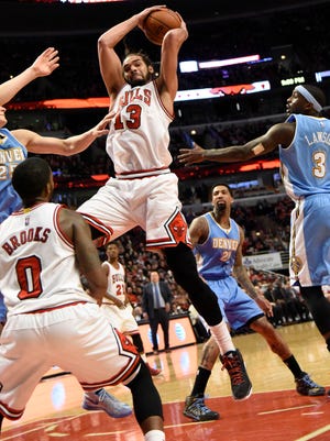 Chicago Bulls center Joakim Noah (13) grabs a rebound in front of Denver Nuggets guard Ty Lawson (3) during the second half at the United Center.