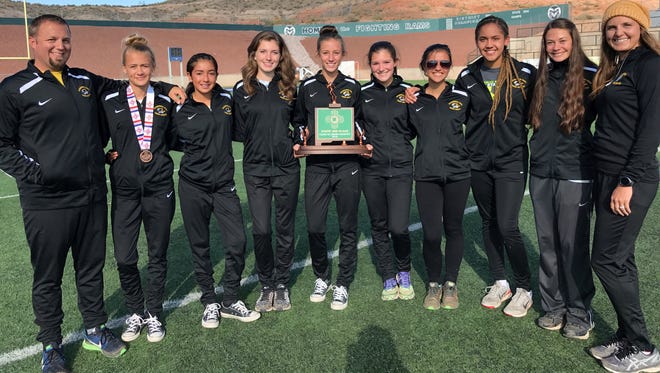 The Alamogordo girls cross country team posed with their third-place trophy Saturday afternoon at Rio Rancho High School.