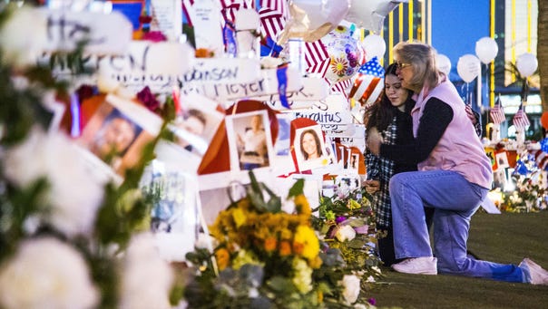 Skylar Carson, 23, left, gets a hug from Midge Elkins as they visit the memorial of 58 crosses at 6 a.m. Oct. 7, 2017, on  Las Vegas Boulevard in Las Vegas after the mass murder a week ago left 58 victims dead and almost 500 wounded.
