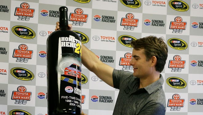 Jeff Gordon holds up an 18-liter bottle of wine he was presented with Friday at Sonoma Raceway.