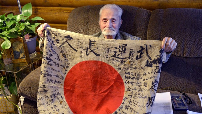This Nov. 11, 2016 photo shows Marvin Strombo of Dixon, Mont. holds a flag that he took from a Japanese officer who died during the Battle of Saipan in 1944. He hopes it will be returned to the family of the soldier. A University of Montana assistant professor identified the soldier as Yasue Sadao.