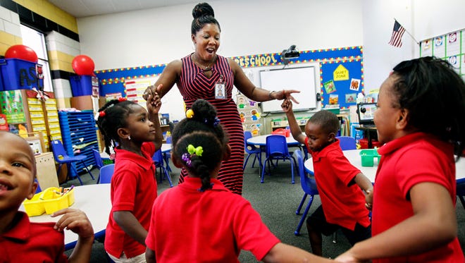 In this file photo, Downtown Elementary School teacher Sherry Barbee (top middle) dances with her preschool students to help release energy before a lesson.