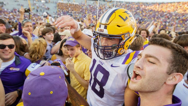LSU's Foster Moreau (18) is surrounded as fans rush the field after the Tigers 36-16 win over Georgia in an NCAA college football in Baton Rouge, La., Saturday, Oct. 13, 2018. (AP Photo/Matthew Hinton)