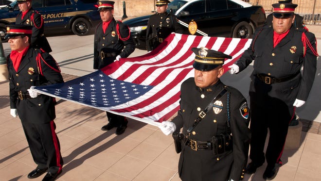 An honor guard of members of the Las Cruces Police Department and the Las Cruces Fire Department present the honor flag at the Patriot Day celebration Sunday evening at the Plaza de Las Cruces.