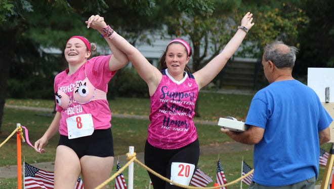 Julia Davis and Brianna Rose finish the "Bras for a Cause" 5K race at Magruder Hospital on Saturday. Davis also won a door prize best design.