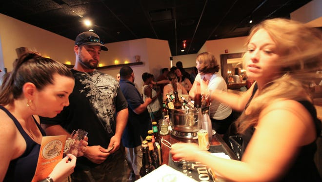 Katie Hicken serves Don and Danielle Wiseman a sample of Troegs at Taverna during the Downtown Newark Food and Brew Fest in 2015.