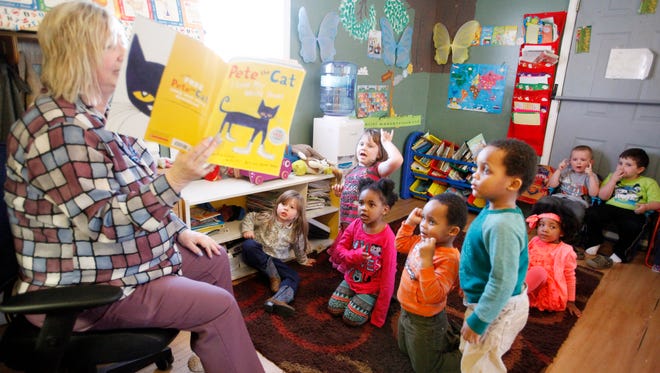 Kathy Tolar reads "Pete the Cat" to children as they read along at Kathy's Kiddie Land.