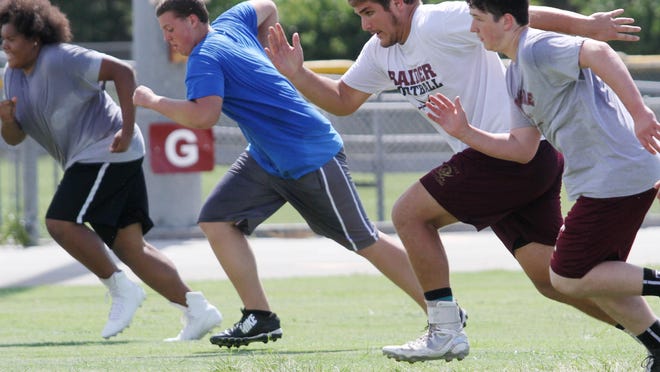 Riverdale’s Cole Schneider, 2nd from right, runs sprints during summer practice last week.