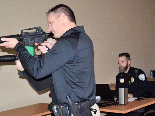Oconto County Deputy Todd Skarban holds a mock rifle as he participates in firearms training last spring at the Sheriff’s Office. Behind him seated is Oconto Falls Police Chief Brad Olsen, who coordinating the simulations for deputies being trained, with Chief Deputy Ed Janke observing.