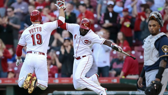 Cincinnati Reds first baseman Joey Votto (19) and second baseman Brandon Phillips (4) do a leaping high-five as Votto crosses the plate on a solo home run in the bottom of the first inning.