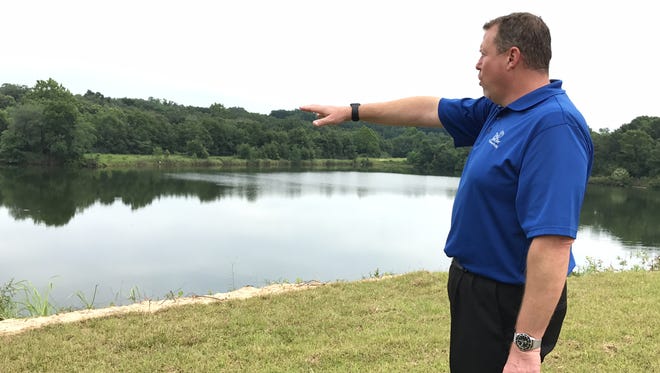 First Tee of Northwest Florida executive director Marty Stanovich points out at the lake that will serve as a floating driving range. The lake where patrons will hit floating balls into is the site of the old Twin Air drive-in movie theater.