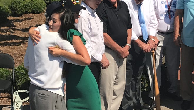 Korean War veterans advocate Hannah Kim hugs a veteran at Conestee Park.