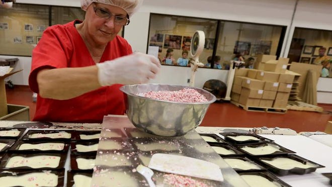
 Deb Bean, 61, adds peppermint sprinkles to white chocolate at the  Sanders factory in Clinton Twp., on Thursday, August 21, 2014. 
