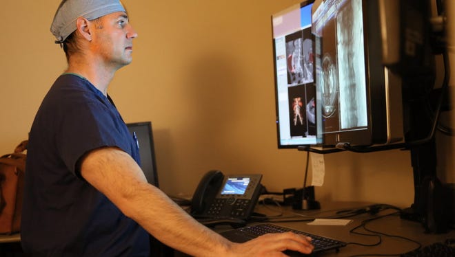 Scott Koss, a interventional radiologist, looks over imagery from a recent patient procedure to repair an aneurysm at ProHealth Care's Waukesha Memorial Hospital.