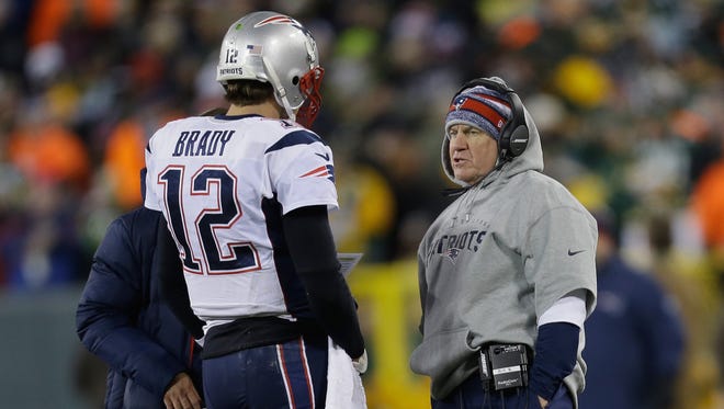 Patriots quarterback Tom Brady talks with coach Bill Belichick in the second quarter during the game at Lambeau Field.