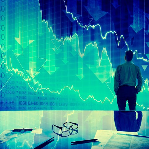 Investor looking at downward pointing stock charts