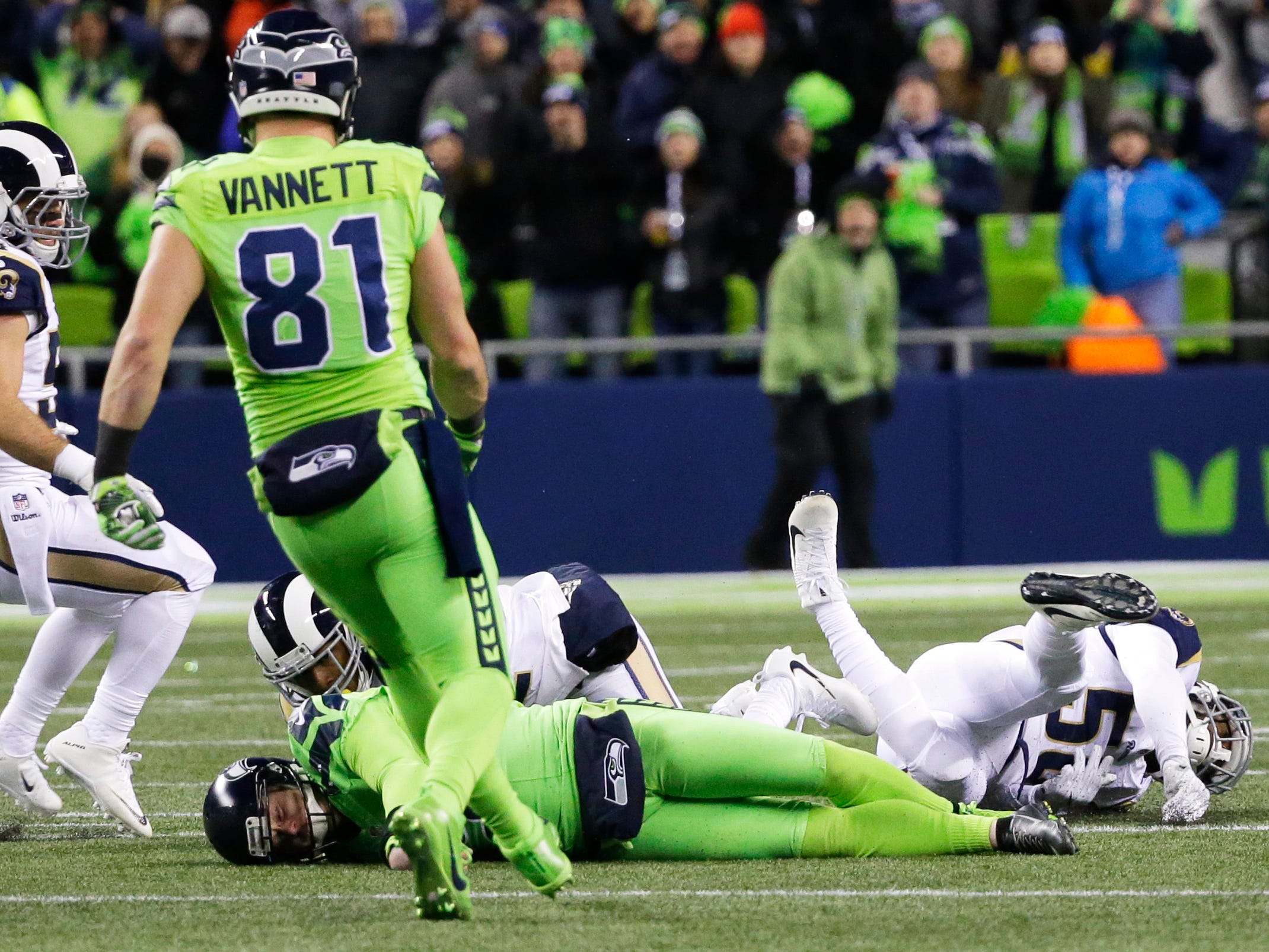 Seattle Seahawks punter Jon Ryan, lower left, lies on the turf after taking a hard hit while running the ball on a fake punt play against the Los Angeles Rams in the second half of an NFL football game, Thursday, Dec. 15, 2016, in Seattle. Ryan left 