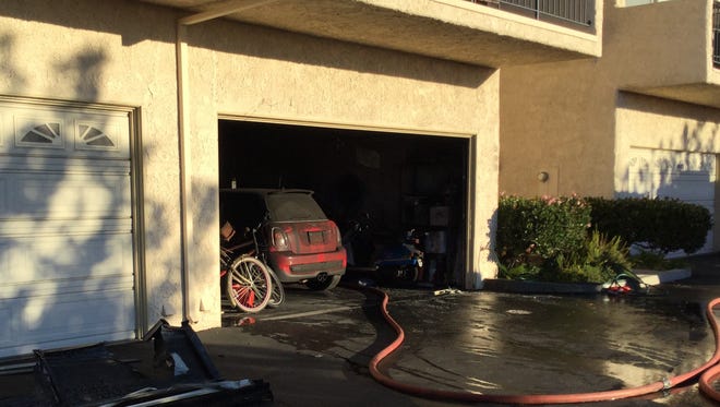 A fire in the ground floor garage of a condominium complex in Ventura displaced two residents Saturday morning.