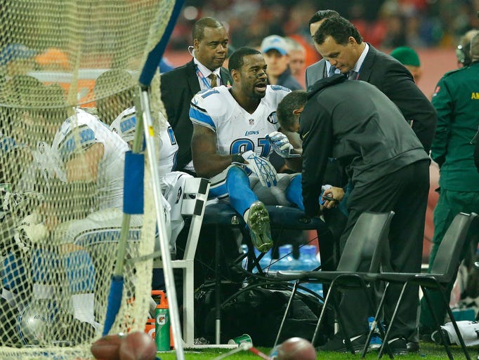 A medic checks the ankle of Detroit Lions WR Calvin
