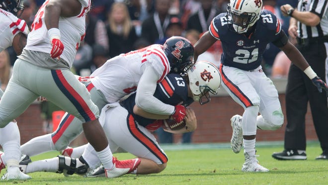Auburn Tigers quarterback Sean White (13) is sacked by Ole Miss defensive end Marquis Haynes (27) during the NCAA football game between Auburn and Ole Miss on Saturday, Oct. 31, 2015, at Jordan-Hare Stadium in Auburn, Ala. Ole Miss defeated Auburn 27-19.