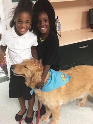 Children from the East Stuart Youth Initiative meet therapy dog Norris, owned by Joan Dutton, for the first time before beginning their Paws to Read sessions for the school year.