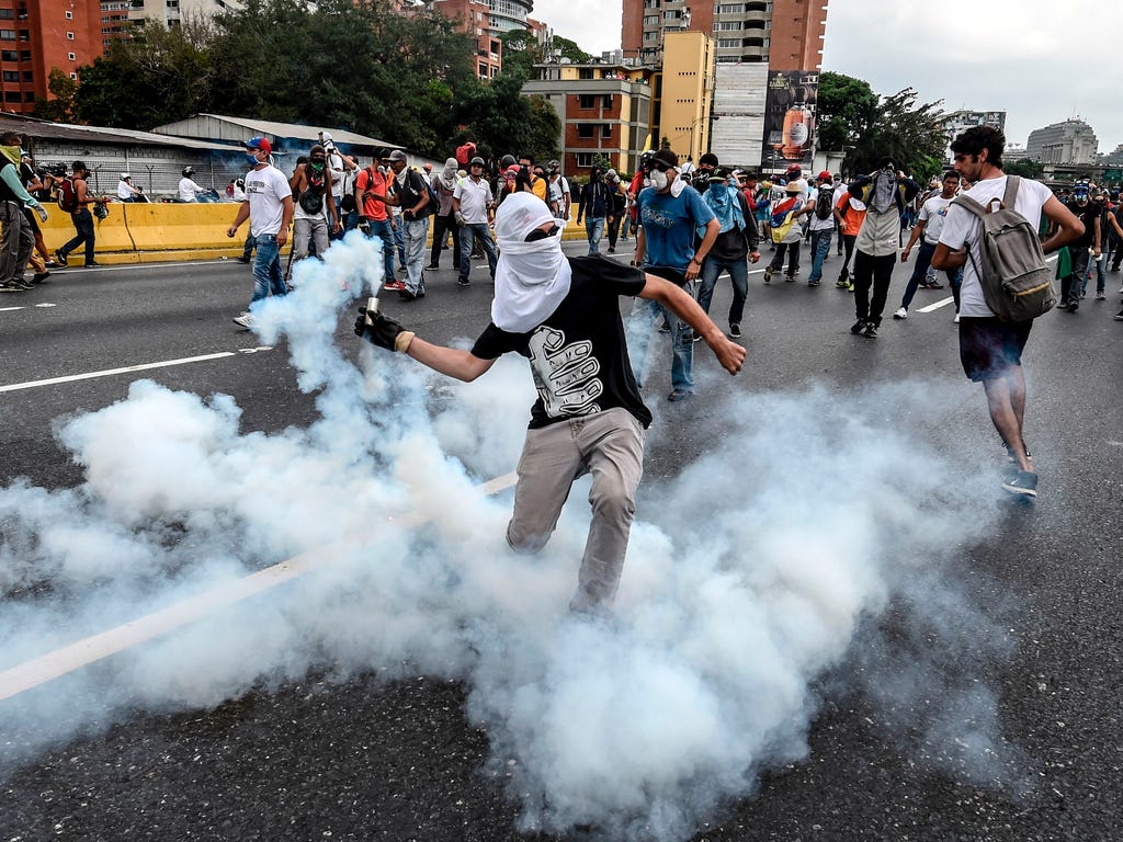 Demonstrators clash with the riot police during a protest against Venezuelan President Nicolas Maduro, in Caracas.\u000d\u000aVenezuelan riot police fired tear gas at groups of protesters seeking to oust Maduro, which have vowed new mass marches afte
