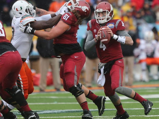 Washington State quarterback Luke Falk scrambles as