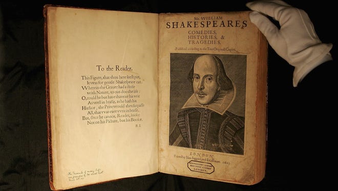 A Sotheby's employee handles a copy of William Shakespeare, The First Folio 1623 in London, England.