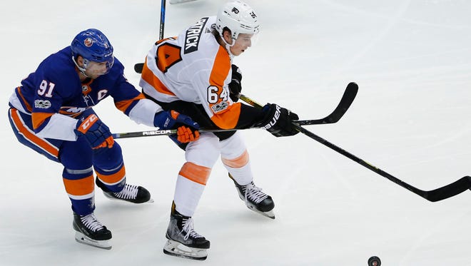 New York Islanders center John Tavares (91) defends against Philadelphia Flyers center Nolan Patrick (64) in the first period of a preseason NHL hockey game in Uniondale, N.Y. , Sunday, Sept. 17, 2017. (AP Photo/Kathy Willens)