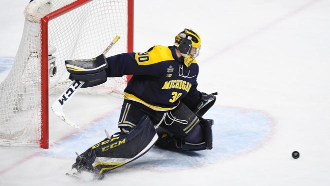 Michigan goaltender Hayden Lavigne gives up a goal to Notre Dame forward Jake Evans in the waning seconds of a semifinal in the NCAA men's college hockey tournament Thursday, April 5, 2018, in St. Paul, Minn.
