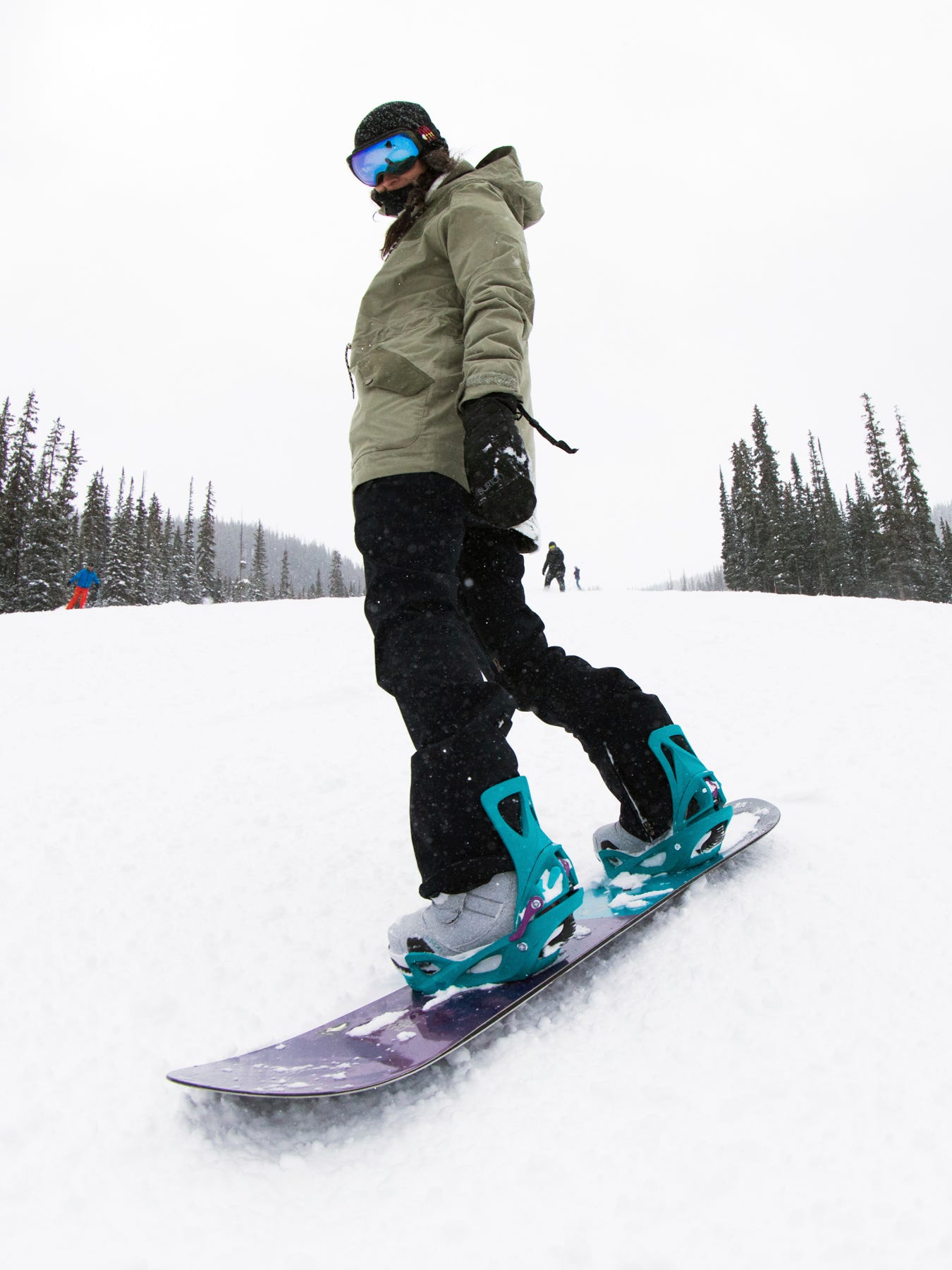 Do you wear your pants tucked under the back of the binding or over Comment why r snowboarding